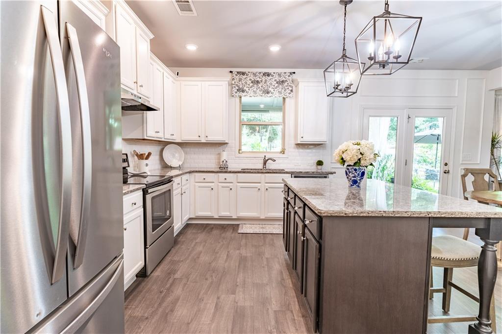 3041 Vista Ridge Braselton, GA 30517 - Photo 19 of 56 a kitchen with granite countertop a sink stainless steel appliances cabinets and a large window