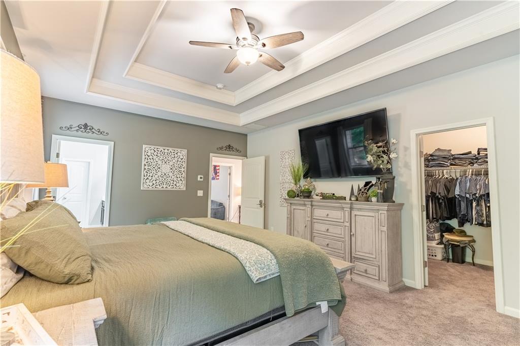 3041 Vista Ridge Braselton, GA 30517 - Photo 24 of 56 a bedroom with a large bed a flat tv screen and furniture