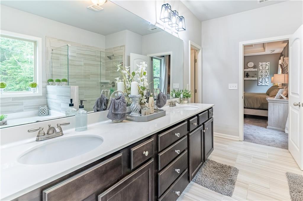 3041 Vista Ridge Braselton, GA 30517 - Photo 28 of 56 a bathroom with double vanity sinks a large mirror and a shower