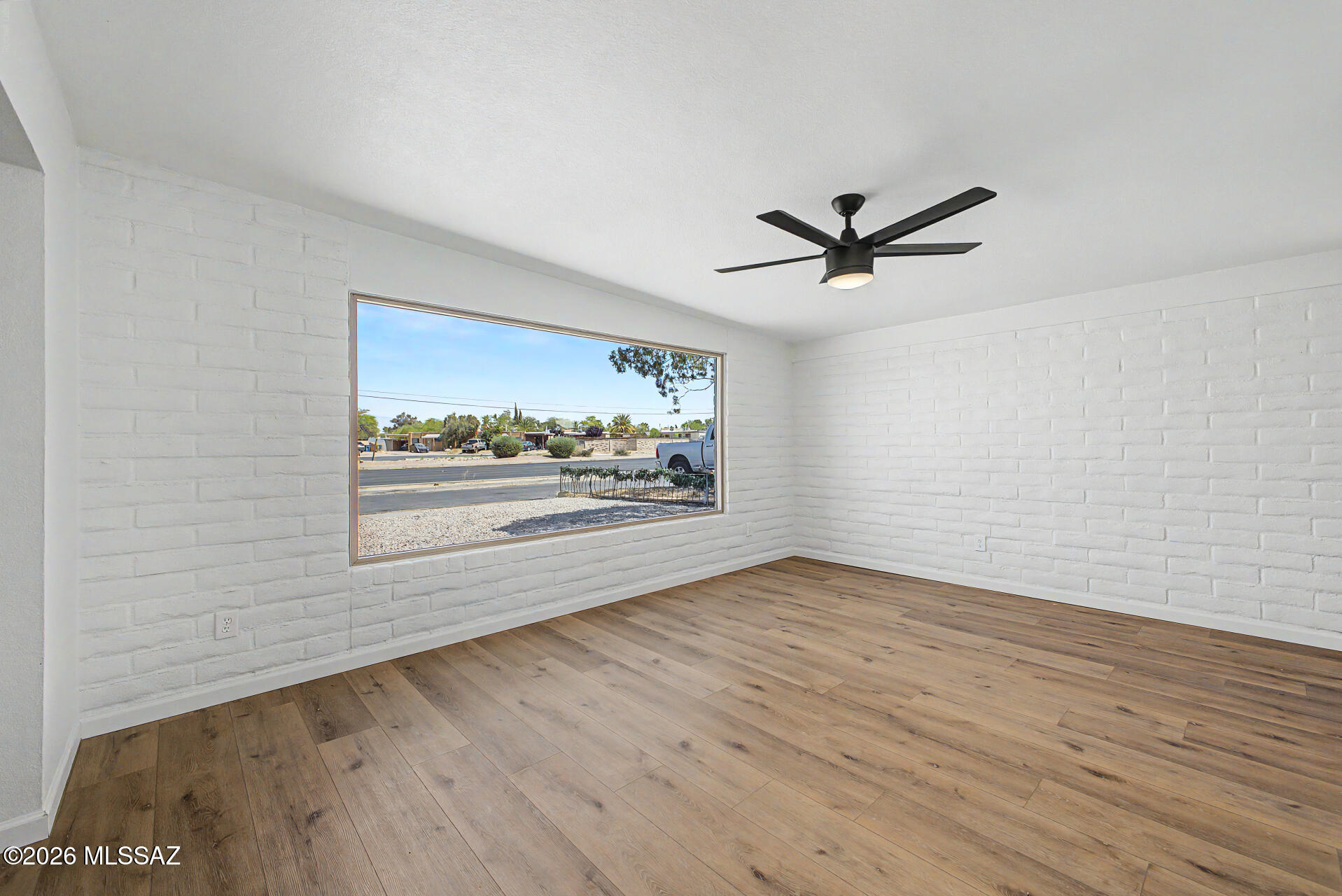 3402 South Kolb Road Tucson, AZ 85730 - Photo 10 of 32 an empty room with wooden floor and ceiling fan