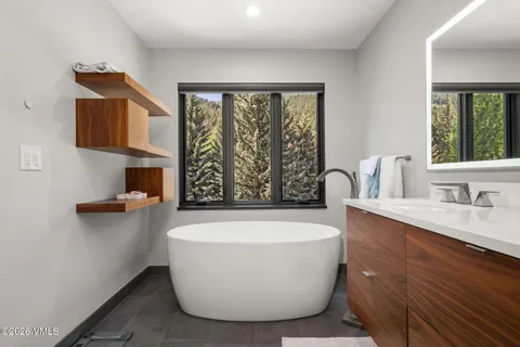 a white bath tub sitting in a bathroom next to a window