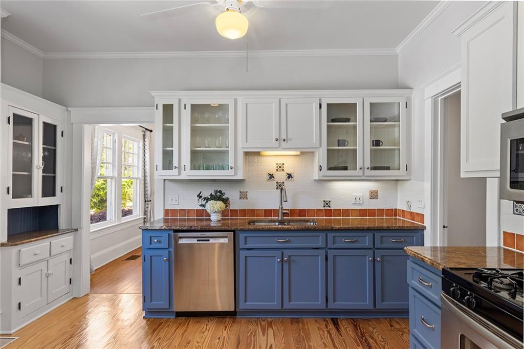 320 Ferguson Street Northeast Atlanta, GA 30307 - Photo 13 of 28 a kitchen with stainless steel appliances granite countertop a sink a stove and wooden cabinets