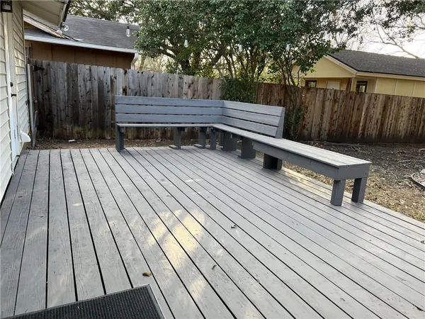 a view of backyard with wooden floor and fence