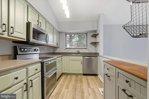 a kitchen with stainless steel appliances granite countertop a sink and a stove