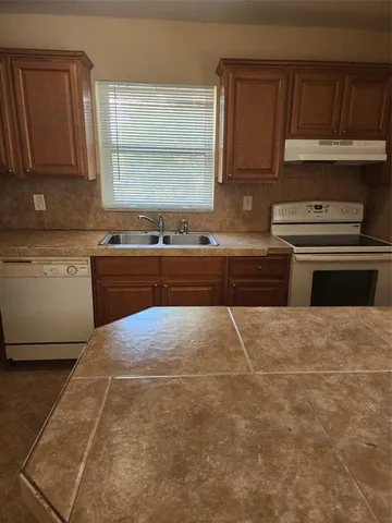 a kitchen with a stove a sink and a microwave