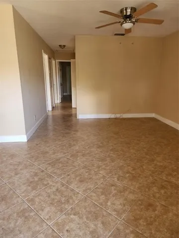 an empty room with a ceiling fan and carpet