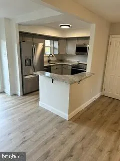 a kitchen with stainless steel appliances a stove a microwave and white cabinets