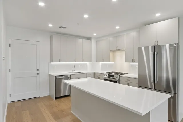 a kitchen with a sink a refrigerator and cabinets