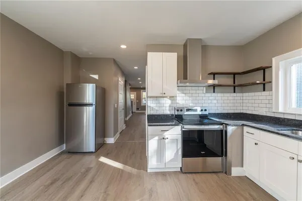 a kitchen with sink a microwave and cabinets