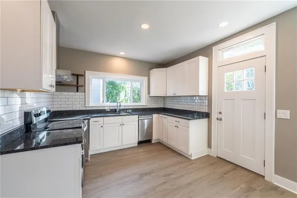 a kitchen with a sink wooden cabinets and white appliances