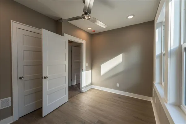 a view of an empty room with a window and wooden floor