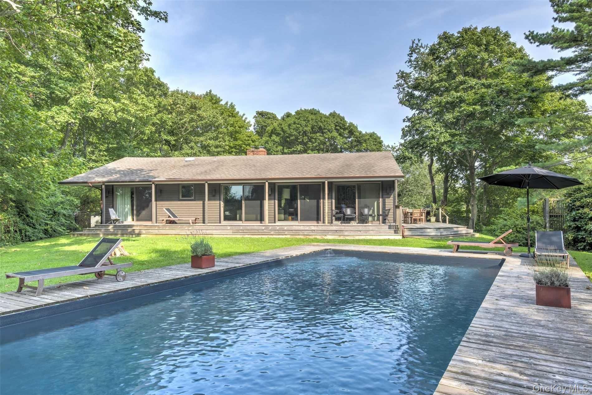 a view of house with swimming pool and yard