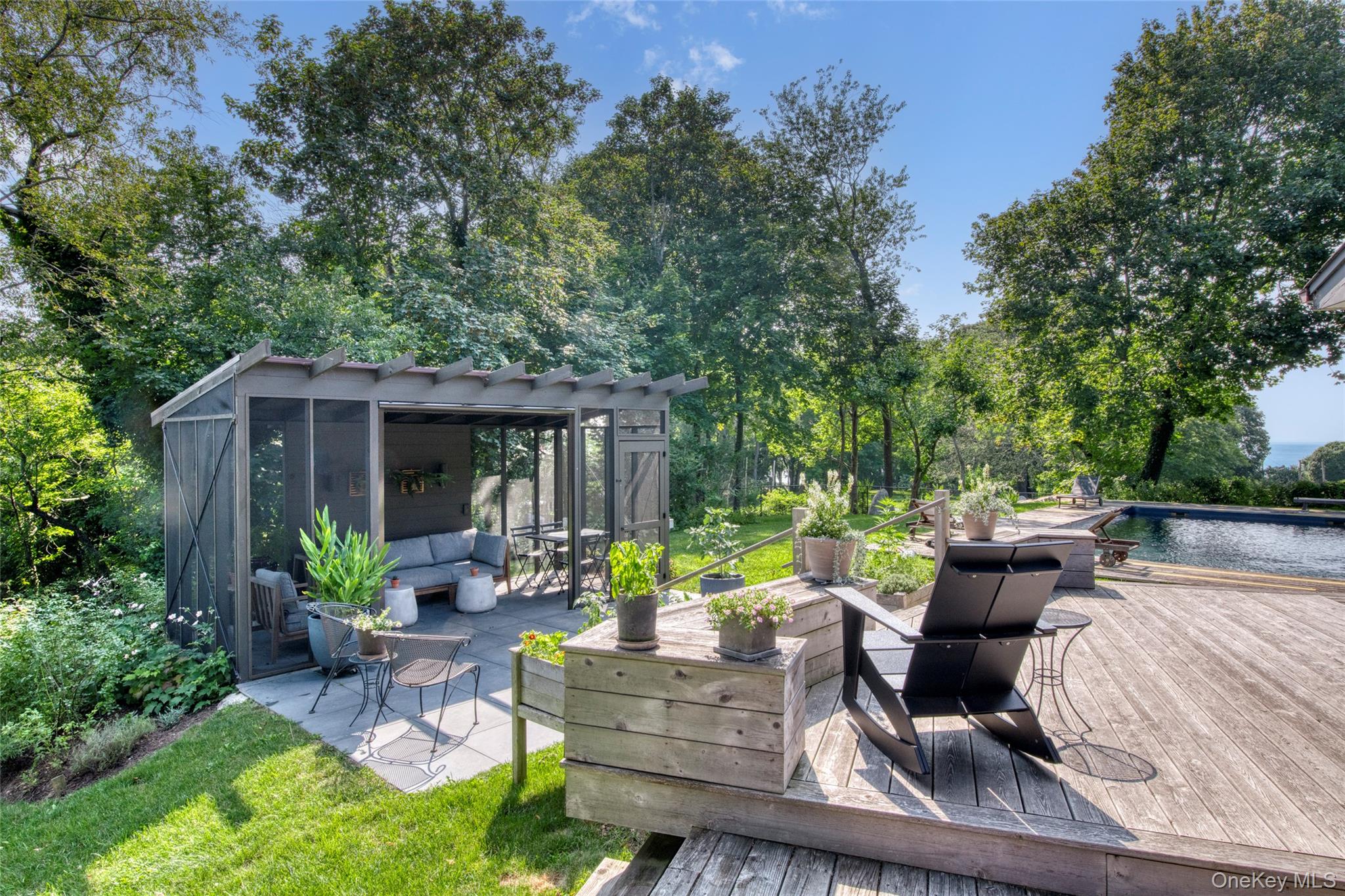 495 Maple Lane Orient, NY 11957 - Photo 3 of 17 a view of a patio with table and chairs potted plants and a large tree