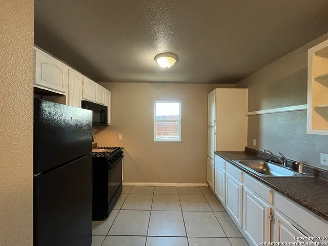 a kitchen with a refrigerator and a sink