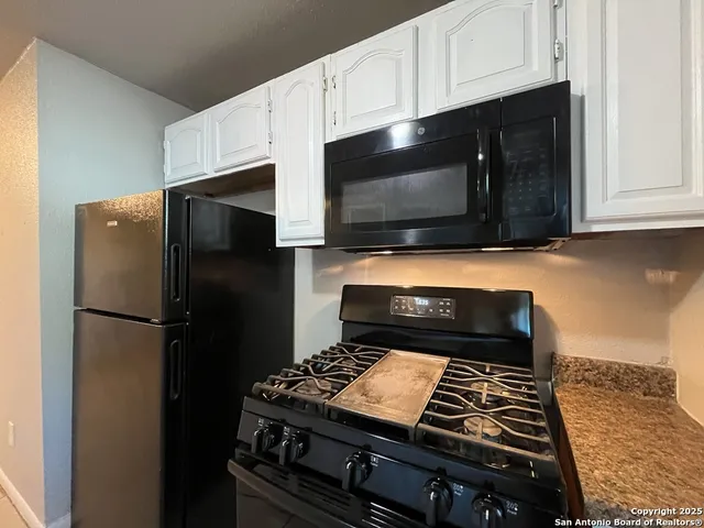 a kitchen with stainless steel appliances granite countertop a stove and a refrigerator
