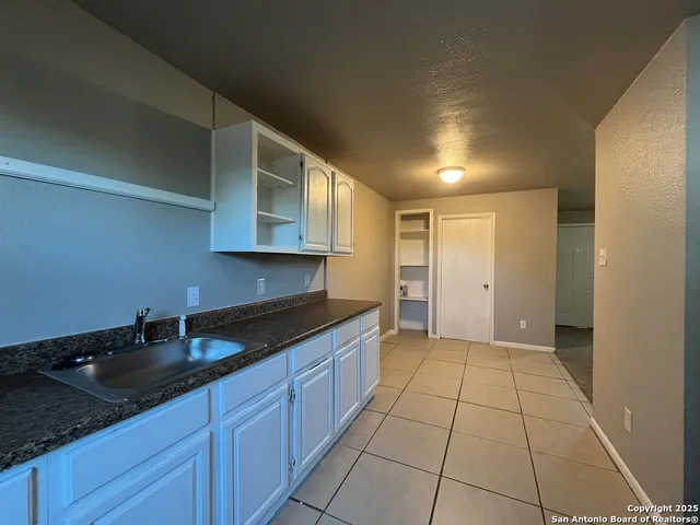 a kitchen with granite countertop a sink and cabinets