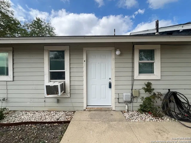 a view of road with card parked on side and retail shops