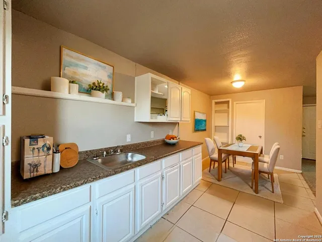 a kitchen with granite countertop a sink and cabinets