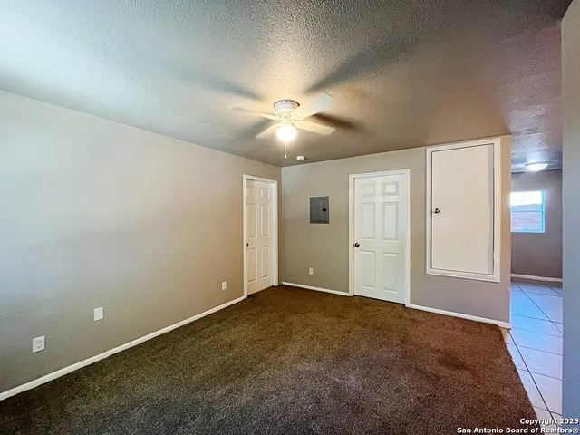 an empty room with closet and a ceiling fan