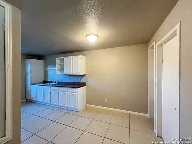 a kitchen with granite countertop a stove a sink and a refrigerator