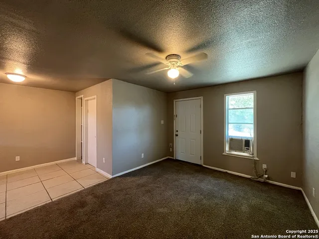 an empty room with windows and fan