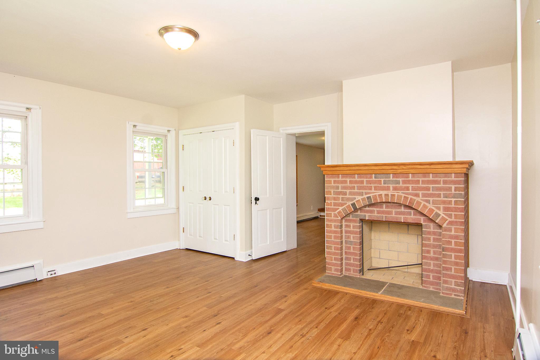 10121 B Clemsonville Road Union Bridge, MD 21791 - Photo 19 of 41 an empty room with wooden floor and fireplace