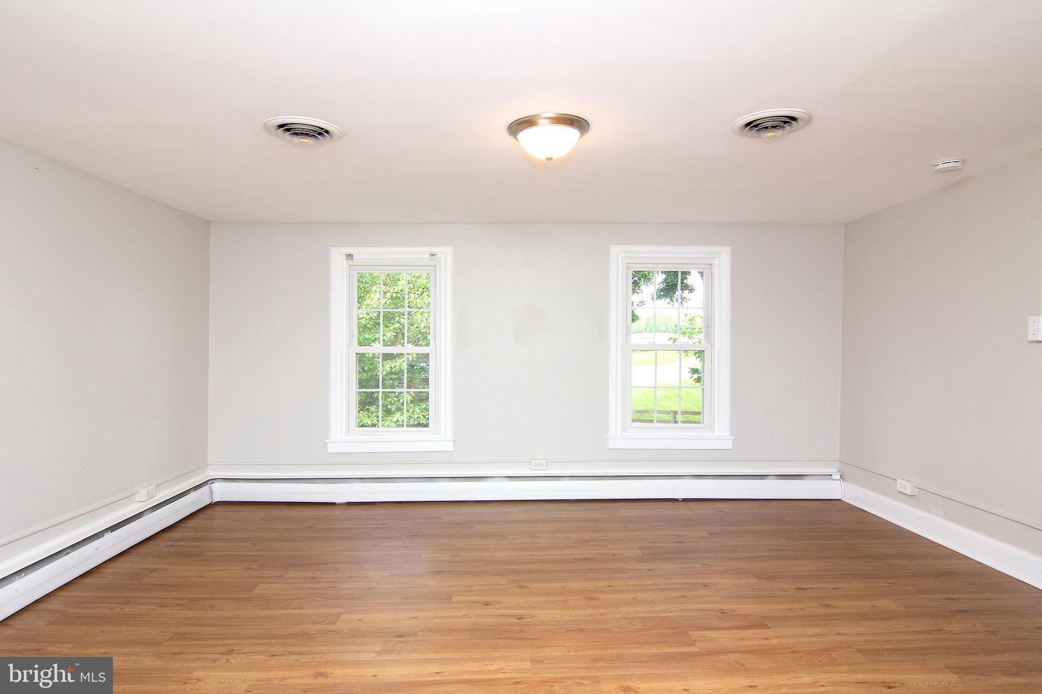 10121 B Clemsonville Road Union Bridge, MD 21791 - Photo 22 of 41 an empty room with wooden floor and windows