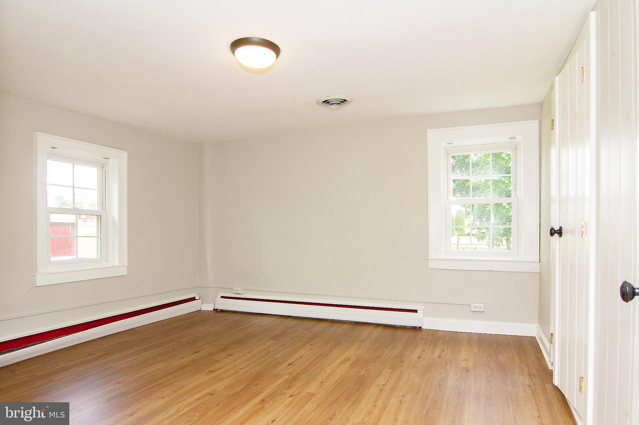 10121 B Clemsonville Road Union Bridge, MD 21791 - Photo 28 of 41 an empty room with wooden floor and windows