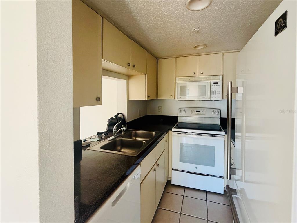 1114 South Pine Ridge Circle, Unit 14 Sanford, FL 32773 - Photo 3 of 10 a kitchen with a stove sink and cabinets