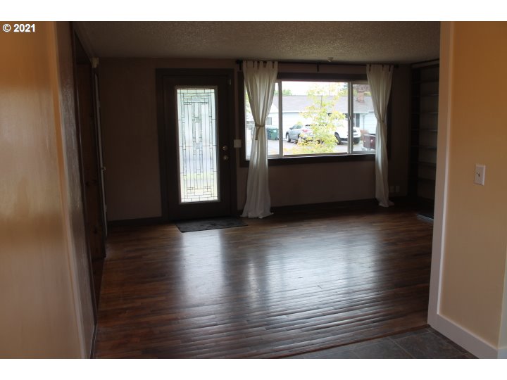 1254 Olympic Street Springfield, OR 97477 - Photo 8 of 30 a view of an empty room with wooden floor and a window