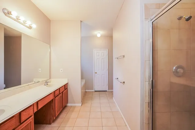 a spacious bathroom with a double vanity sink a mirror and a shower