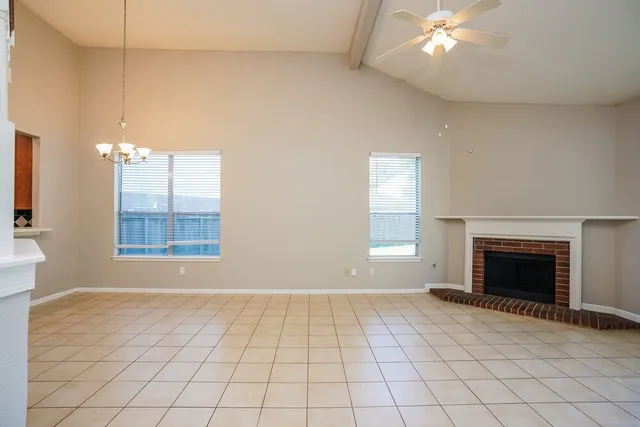 wooden floor fireplace and windows in an empty room