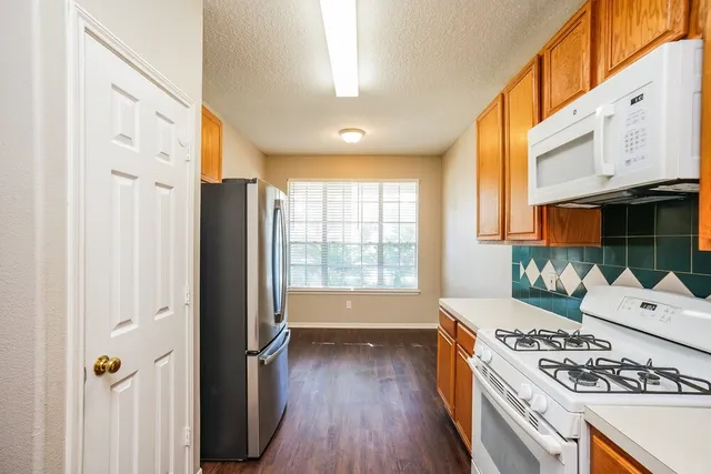 a kitchen with stainless steel appliances granite countertop a stove and a refrigerator