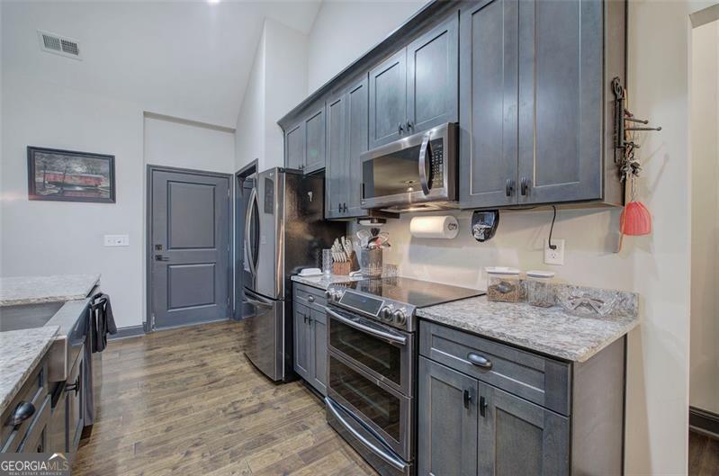 127 Alex Calhoun, GA 30701 - Photo 15 of 53 a kitchen with kitchen island granite countertop stainless steel appliances and wooden cabinets