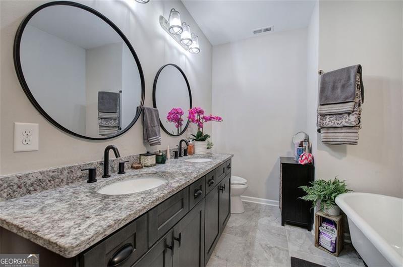 127 Alex Calhoun, GA 30701 - Photo 24 of 53 a bathroom with a granite countertop sink a mirror and a toilet