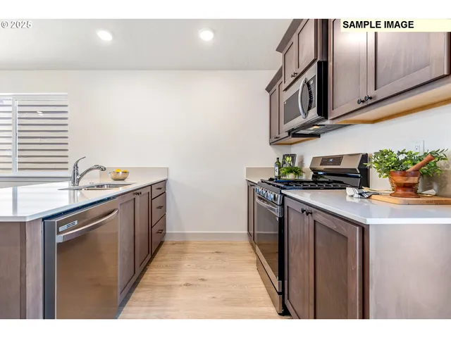 a kitchen with stainless steel appliances granite countertop a sink stove and cabinets