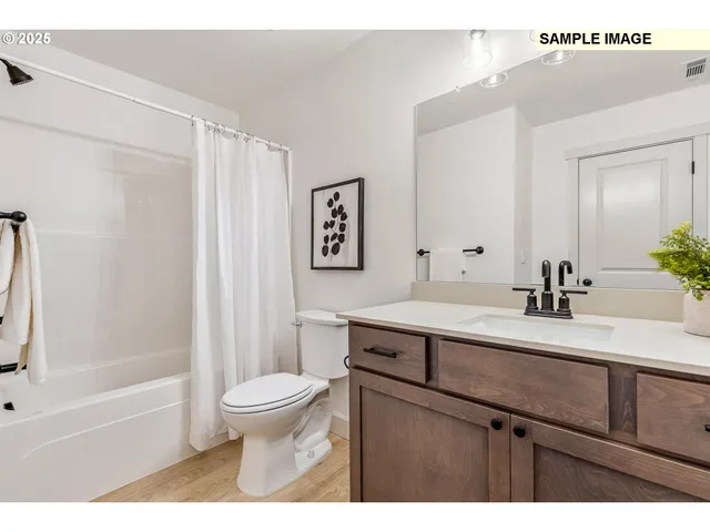a bathroom with a sink a toilet and a large mirror