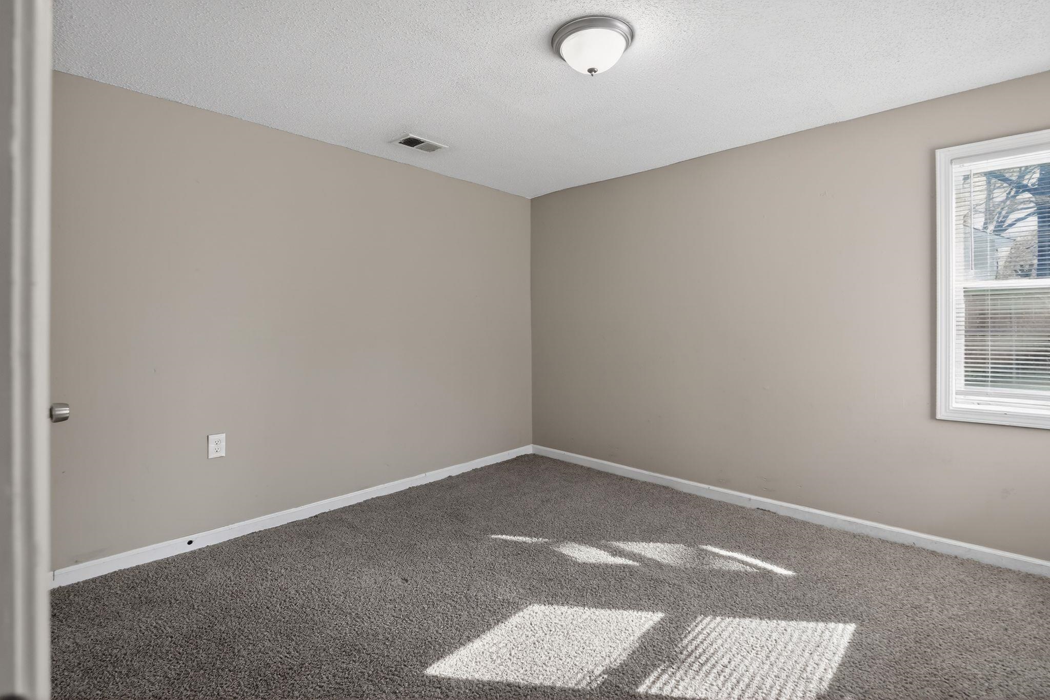 4043 Clearpool Circle Road Memphis, TN 38118 - Photo 21 of 33 Carpeted empty room with baseboards and a textured ceiling