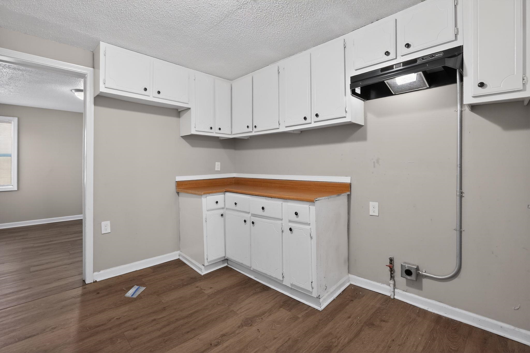 4043 Clearpool Circle Road Memphis, TN 38118 - Photo 24 of 33 Kitchen with a textured ceiling, white cabinets, range hood, and dark wood finished floors