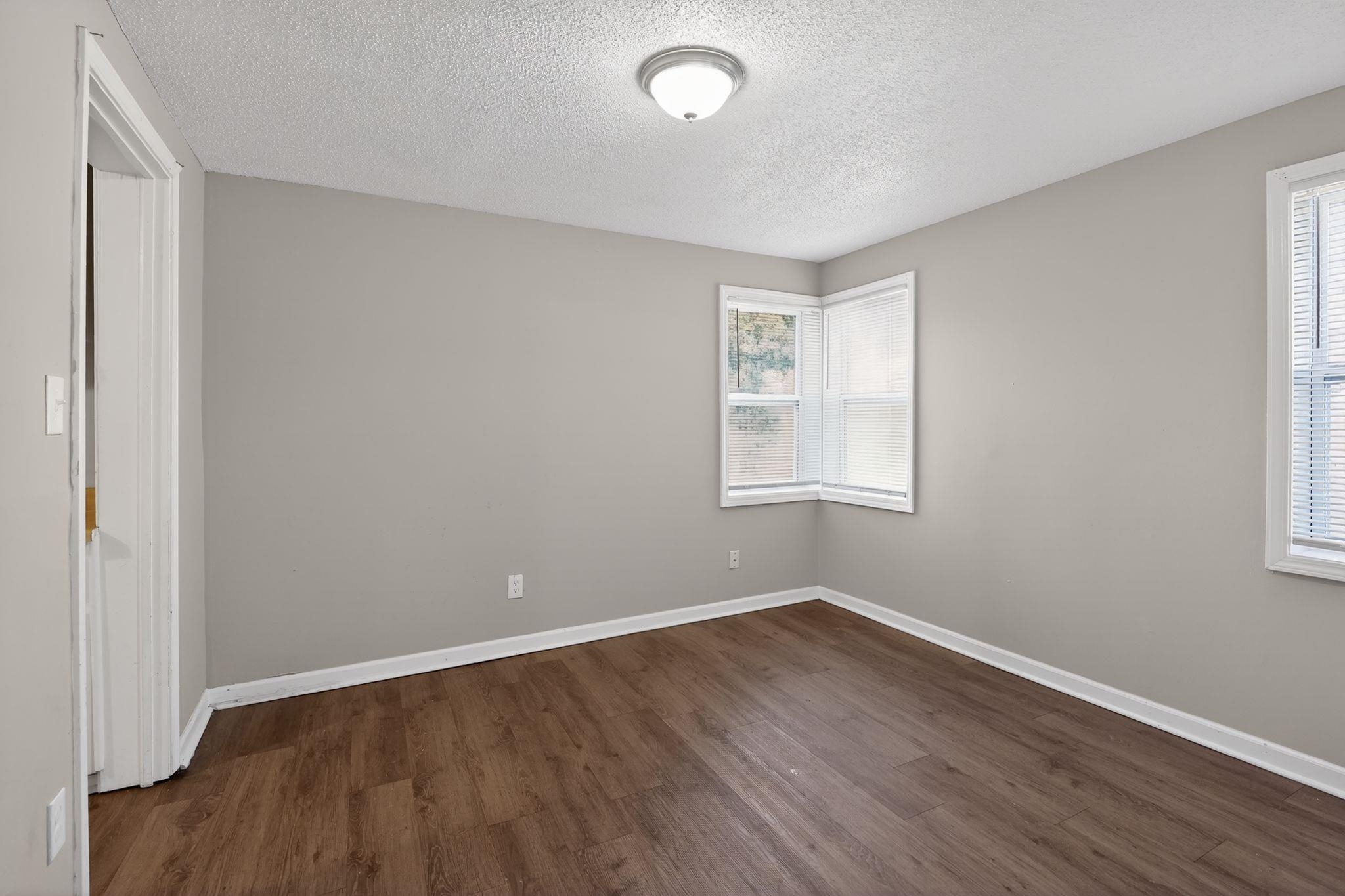 4043 Clearpool Circle Road Memphis, TN 38118 - Photo 28 of 33 Unfurnished bedroom with dark wood-style flooring and a textured ceiling