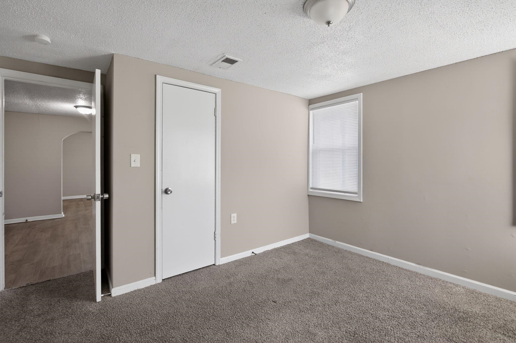 4043 Clearpool Circle Road Memphis, TN 38118 - Photo 33 of 33 Unfurnished bedroom featuring arched walkways, a textured ceiling, and carpet flooring