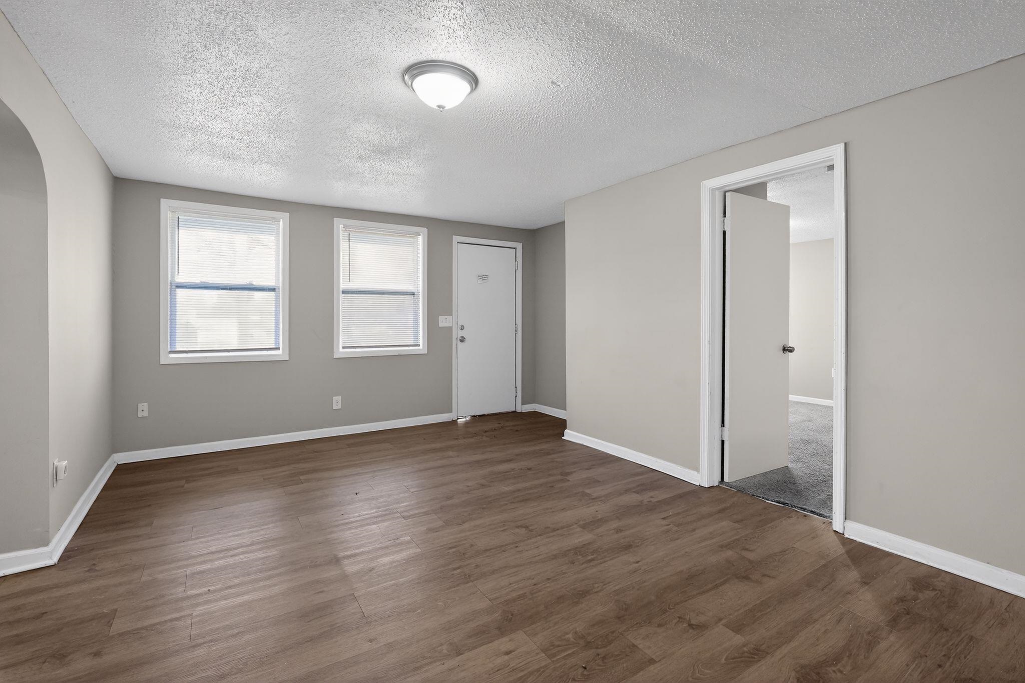4043 Clearpool Circle Road Memphis, TN 38118 - Photo 7 of 33 an empty room with wooden floor and windows