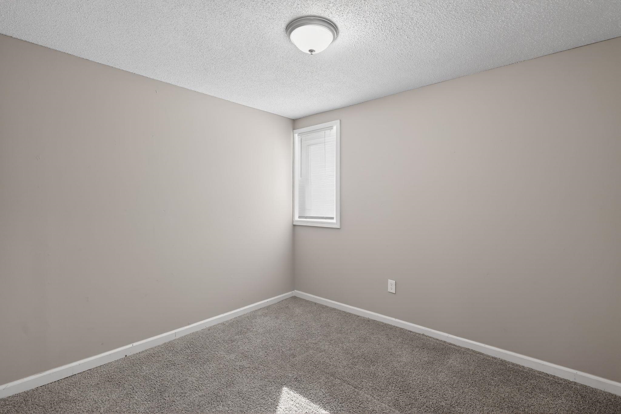 4043 Clearpool Circle Road Memphis, TN 38118 - Photo 9 of 33 Carpeted spare room featuring baseboards and a textured ceiling