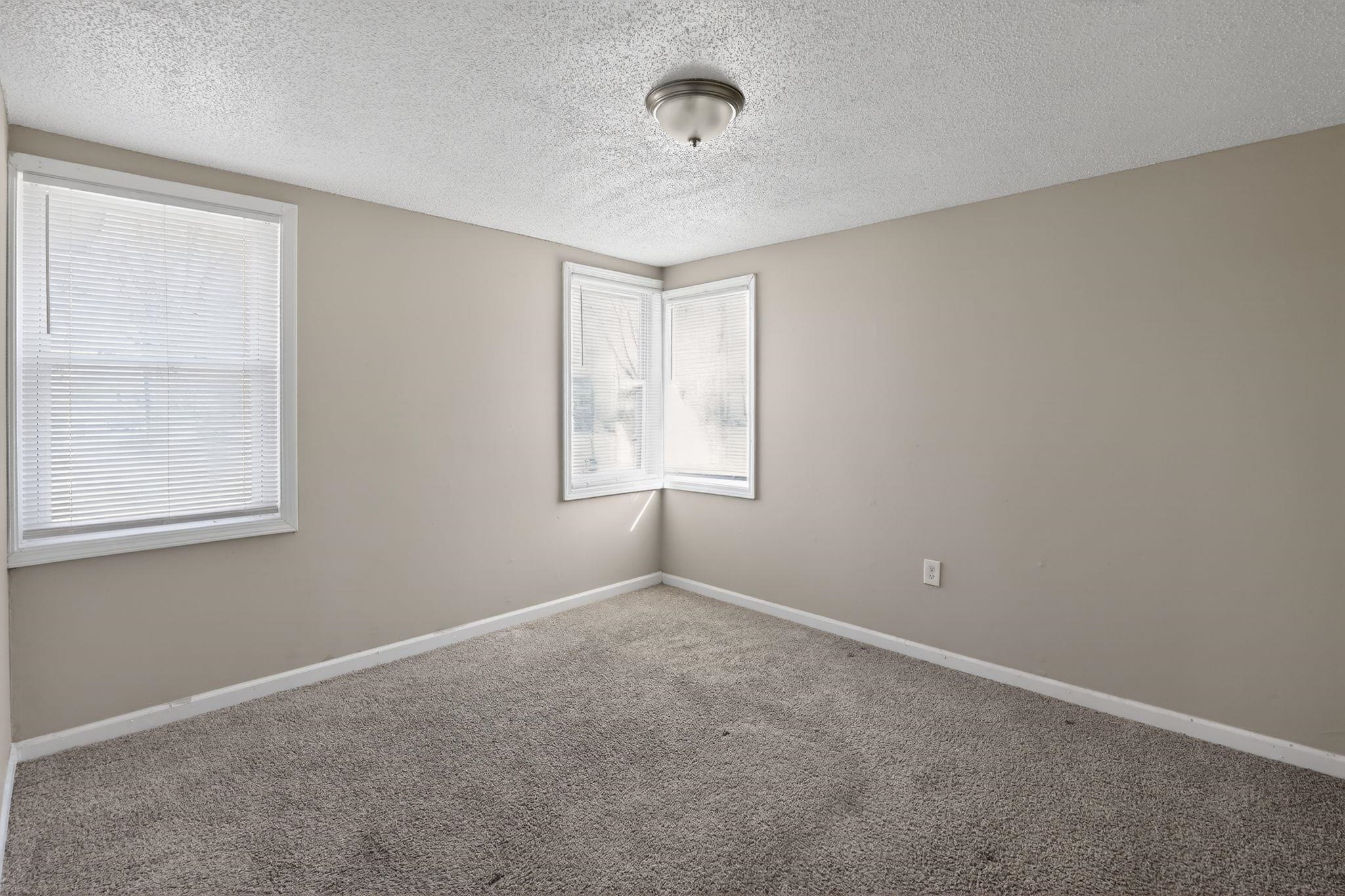 4043 Clearpool Circle Road Memphis, TN 38118 - Photo 10 of 33 Carpeted empty room featuring baseboards and a textured ceiling