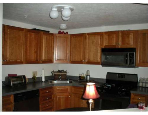 30 Caspian Way, Unit 30 Fitchburg, MA 01420 - Photo 4 of 10 a kitchen with a sink a stove cabinets and a view of living room