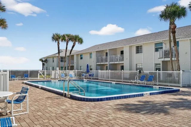 a view of a house with swimming pool and sitting area