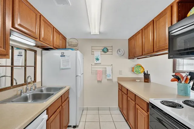 a kitchen with stainless steel appliances granite countertop a sink stove refrigerator and cabinets