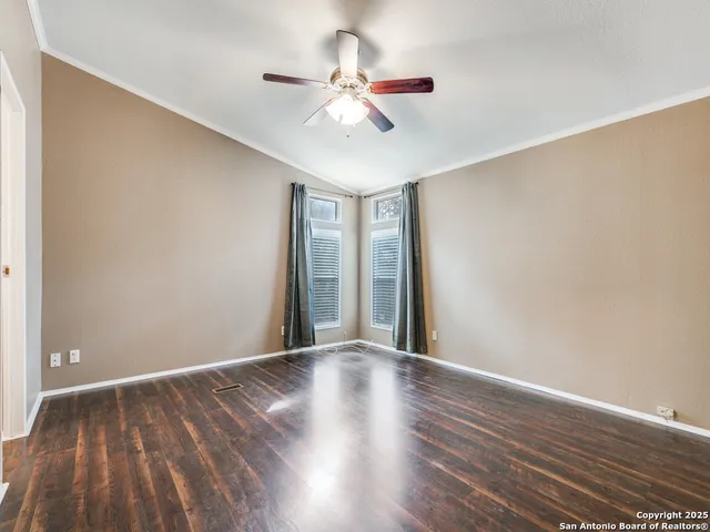 a view of an empty room with wooden floor