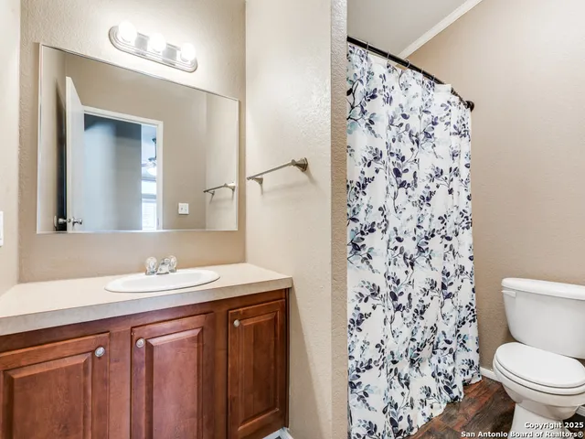 a bathroom with a granite countertop sink a toilet and a mirror
