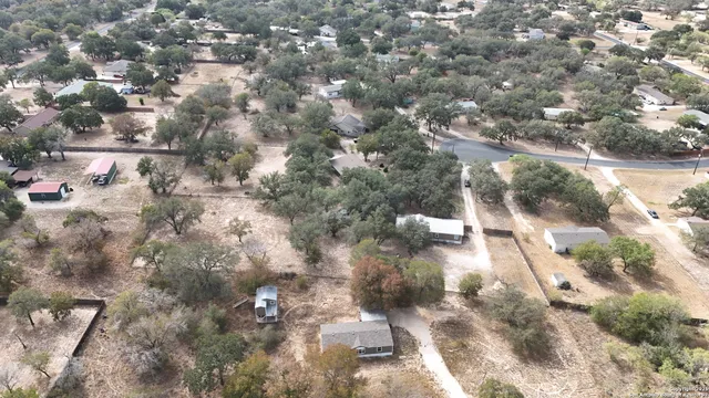 an aerial view of a house with yard and mountain view in back